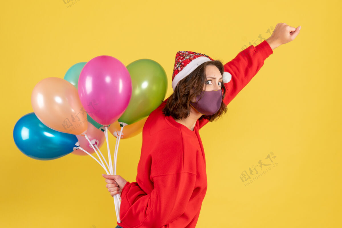 气球正面图：戴着黄色面具手持气球的年轻女子飞机女人正面