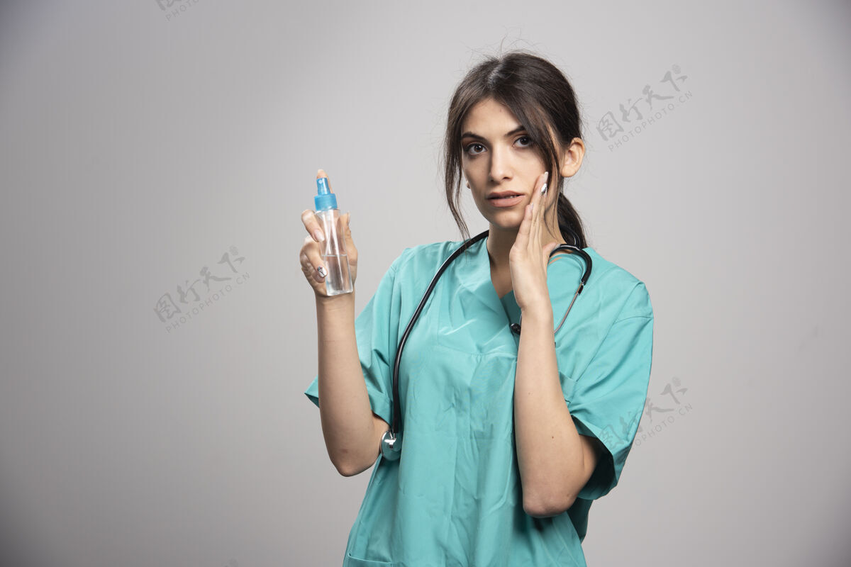 医生女医生拿着听诊器拿着喷雾瓶工作职业医疗