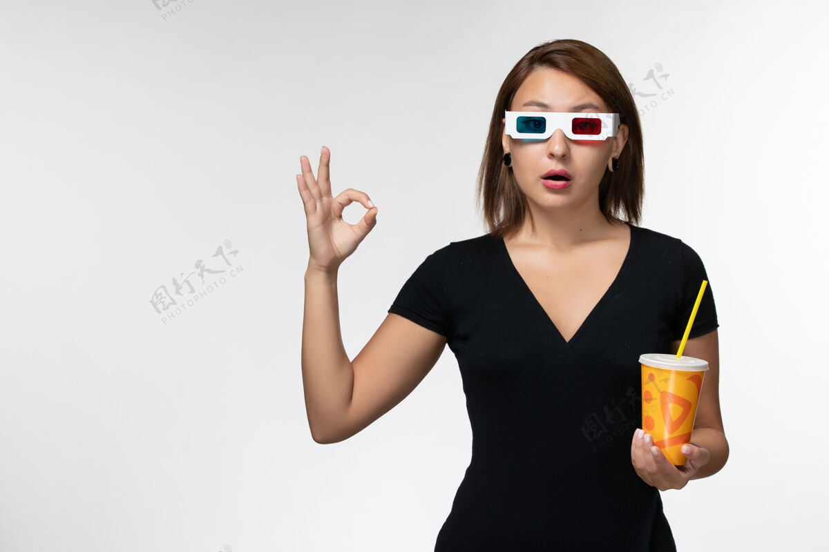 举行正面图：戴着d型太阳镜拿着苏打水的年轻女性 浅白色表面太阳镜汽水电影