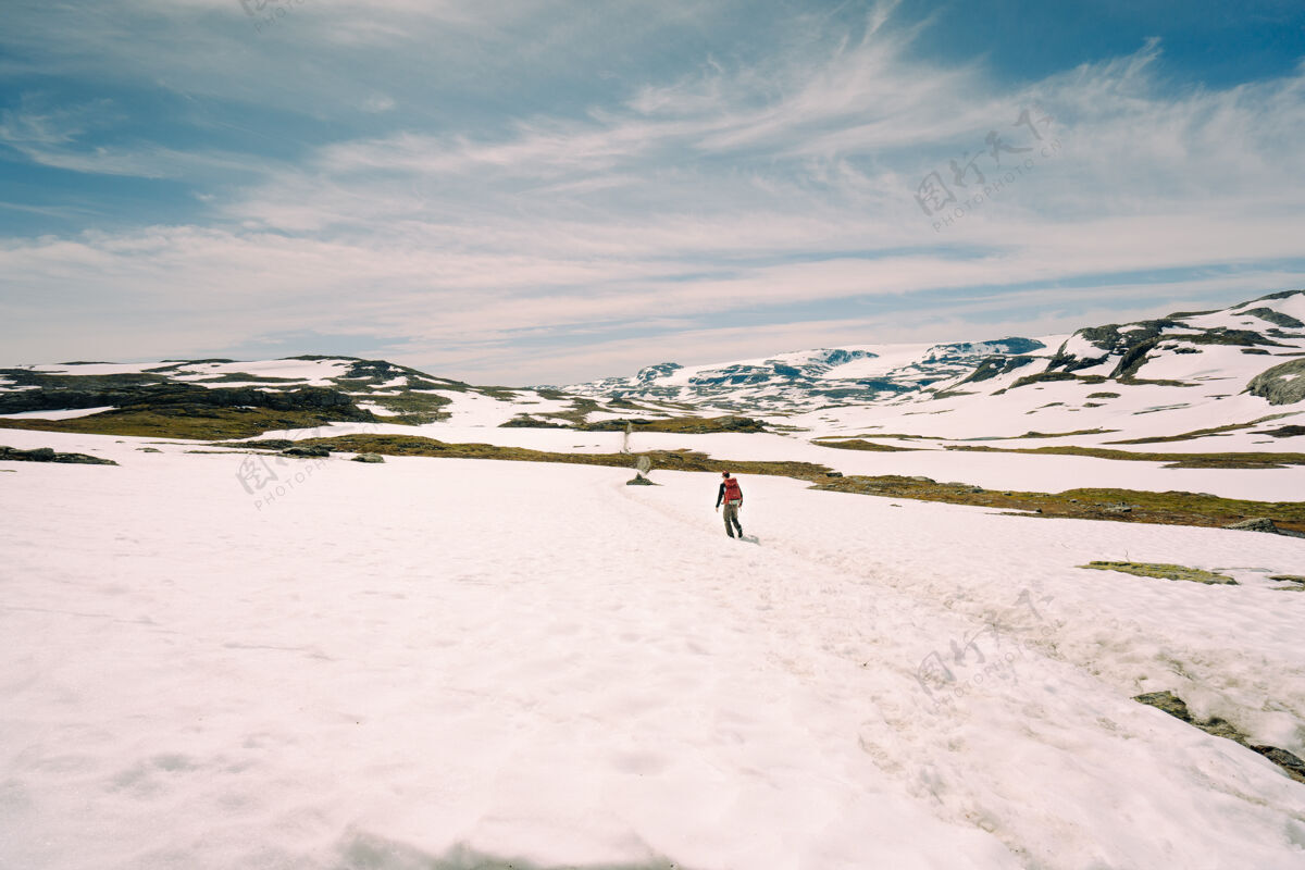 岩一个男人在雪山上行走的低角度镜头雪景冰