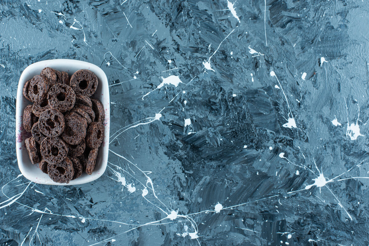 可口美味的巧克力涂层玉米圈在一个碗里 在大理石背景上玉米圈巧克力糖