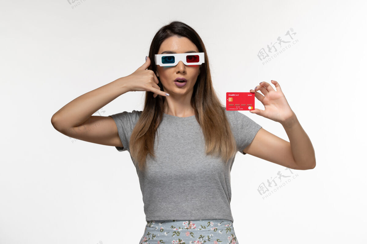 电影正面图白色表面上戴着d墨镜拿着银行卡的年轻女性女性持有遥远