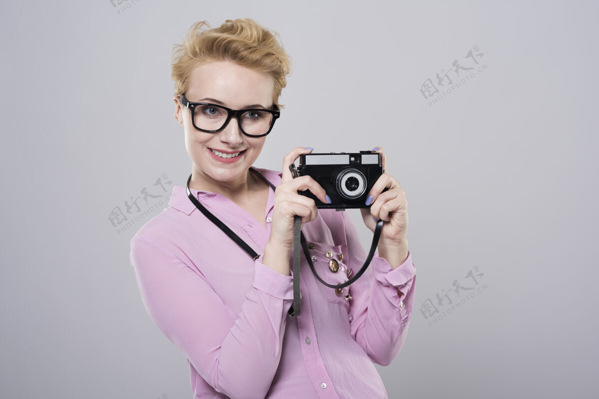 姿势用复古相机拍照的女人微笑拍照条纹