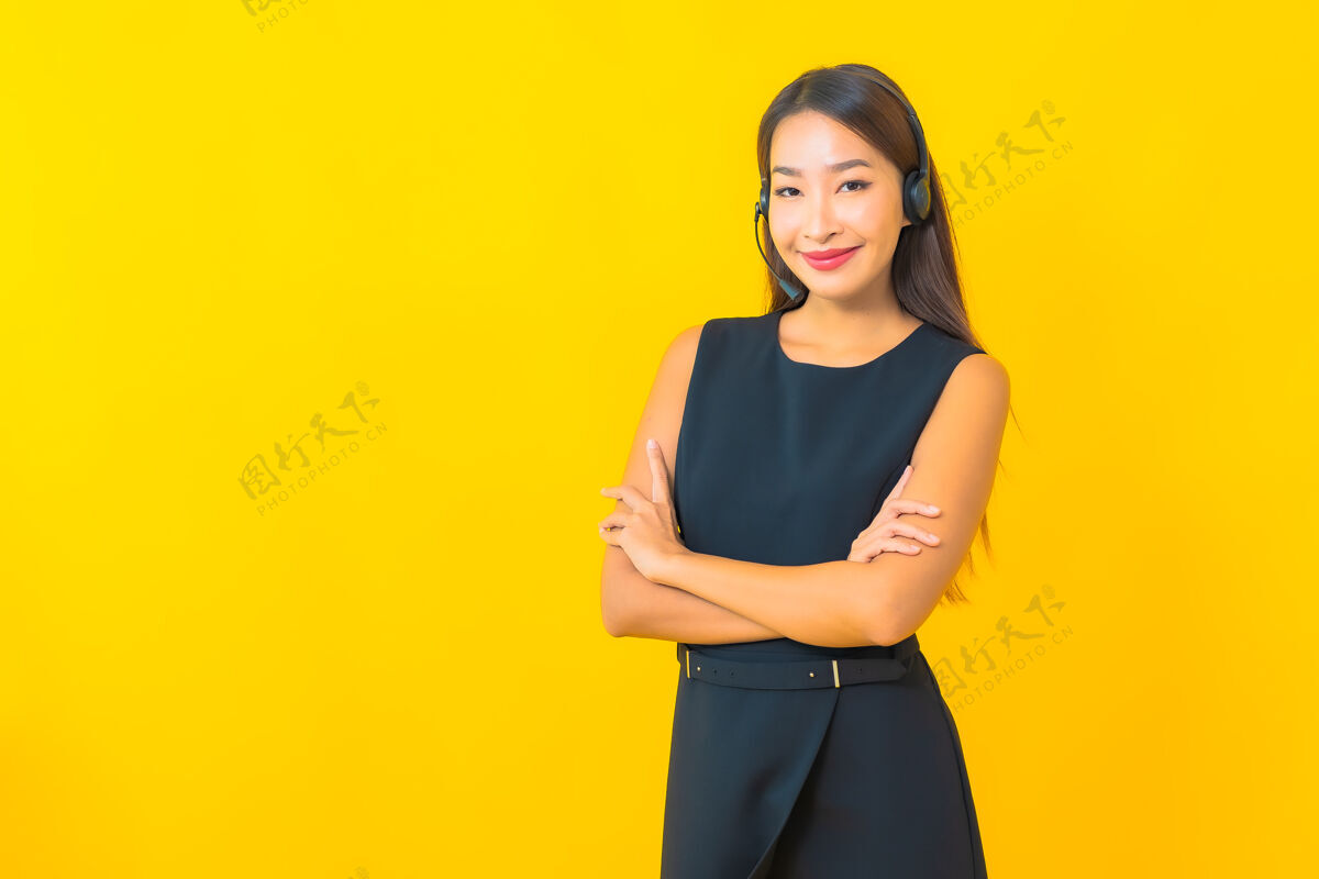 工人肖像美丽的年轻亚洲女商人与耳机呼叫中心客户关怀黄色背景助理代理服务
