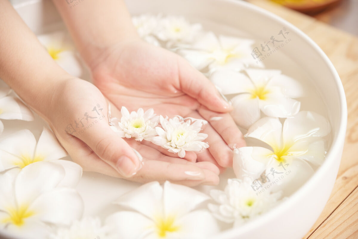 湿润水疗治疗和产品在水疗香薰水疗陶瓷碗白花健康手指皮肤