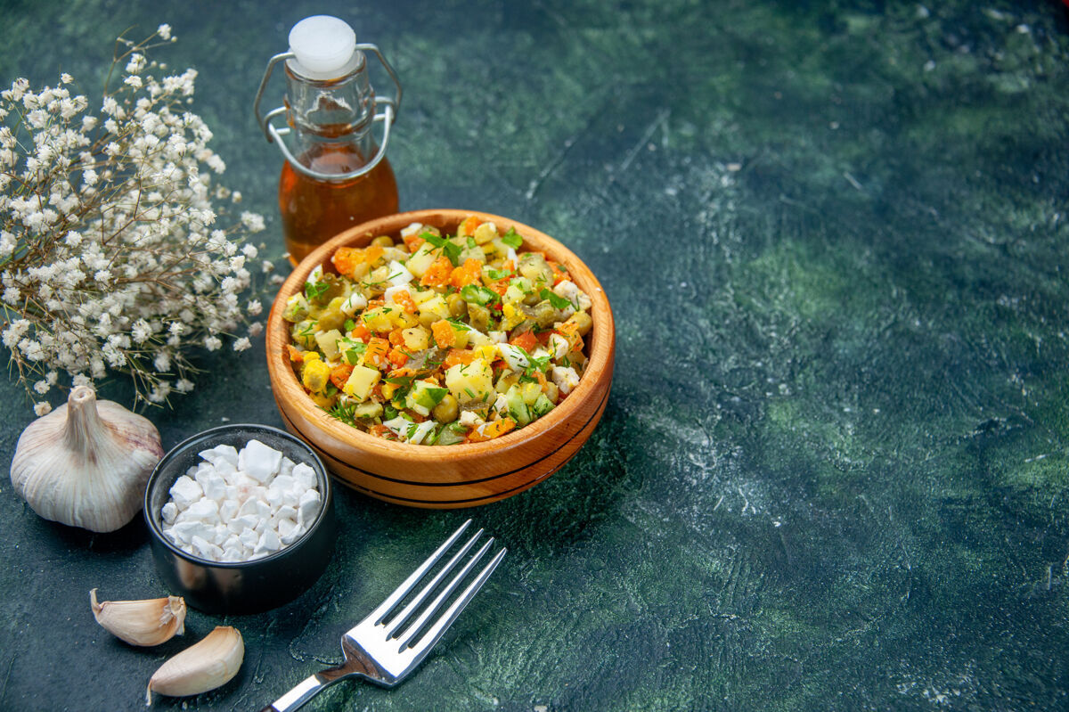 健康在黑暗的背景下看到美味的蔬菜沙拉前面香料碗
