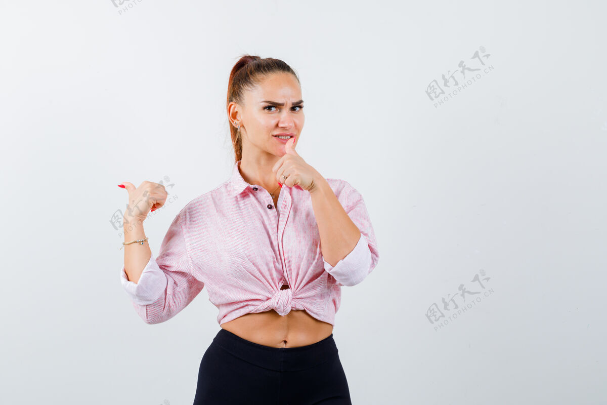 衬衫年轻女性在休闲衬衫 裤子上竖起大拇指 看起来很快乐 前视图健康皮肤护理休闲