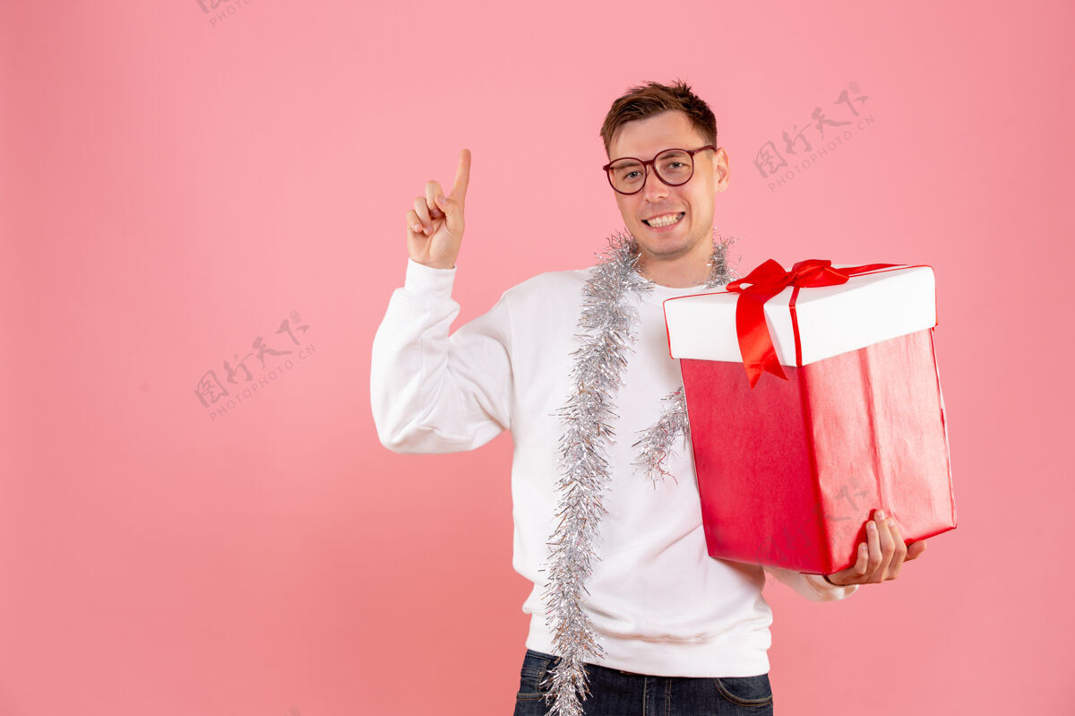 女士正面图：年轻男性 粉色背景 圣诞礼物肖像圣诞微笑