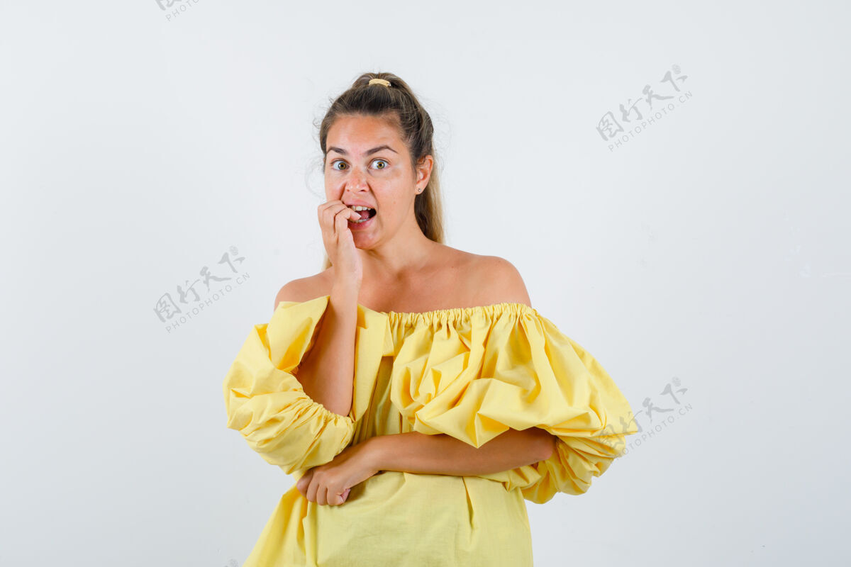 黄色一幅身穿黄色连衣裙的年轻女士咬指甲的画像 正从正前方看去衣服指甲肖像
