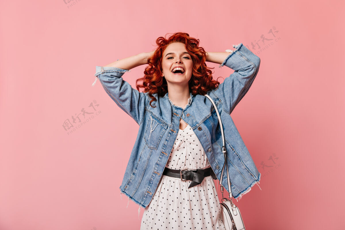 孤立的粉红色粉色背景下的浪漫女人笑的正面图穿着休闲牛仔夹克的幽默女孩的摄影棚照片时尚粉色背景一个人