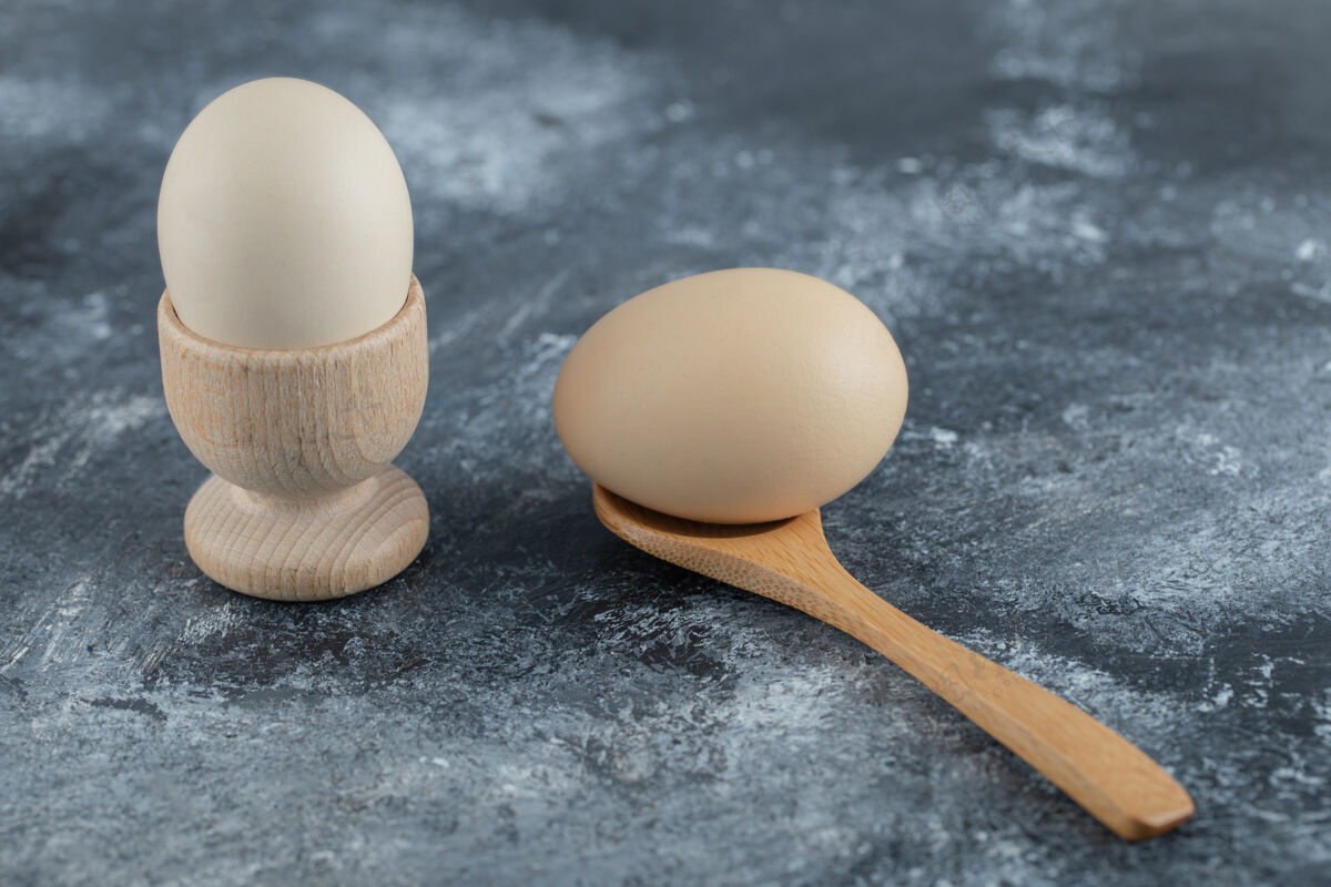 勺子煮鸡蛋和木勺放在大理石上鸡蛋生的木头
