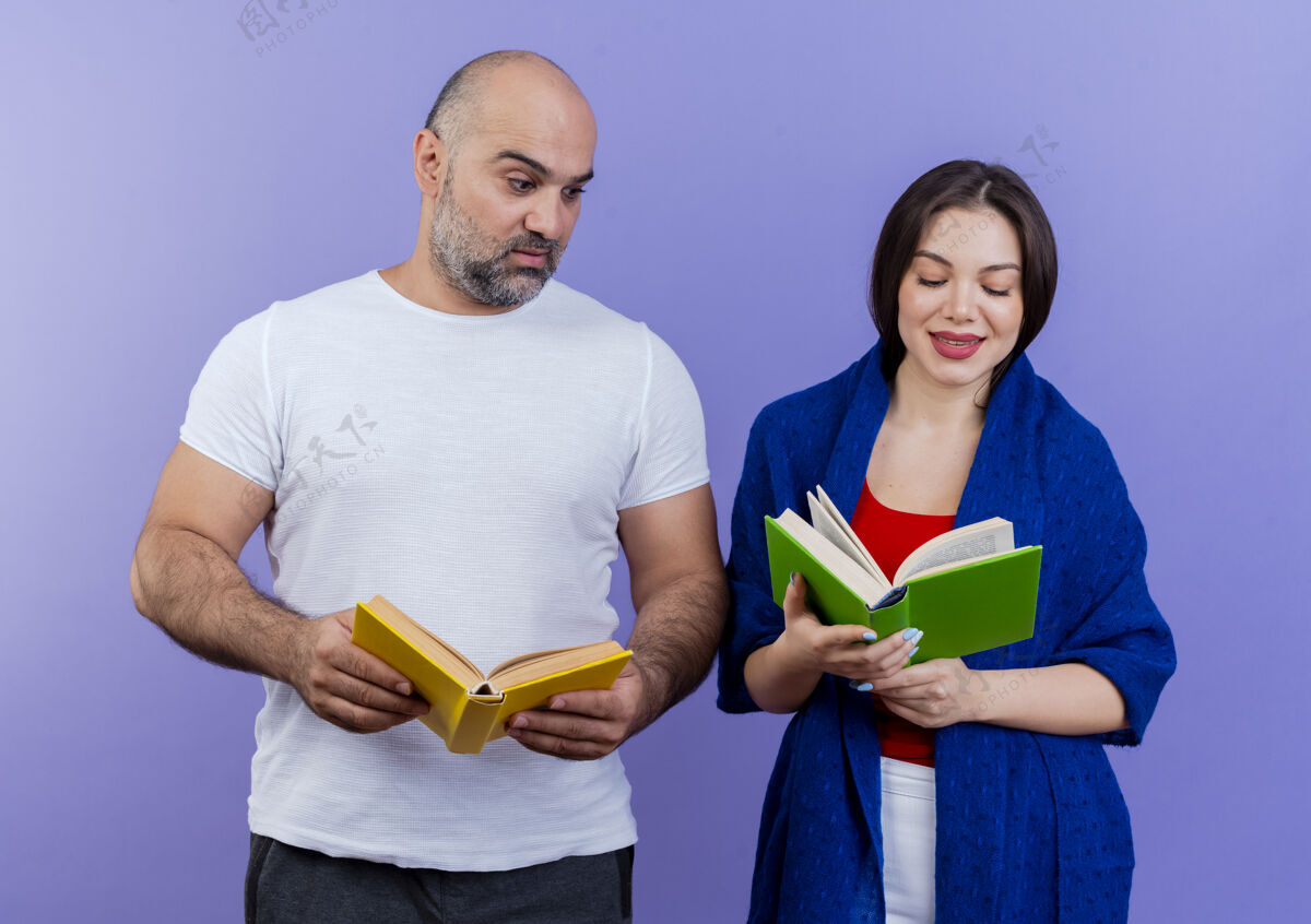 阅读成年夫妇高兴的女人裹着披肩看书打动了男人拿着书看着她的书紫色请包装