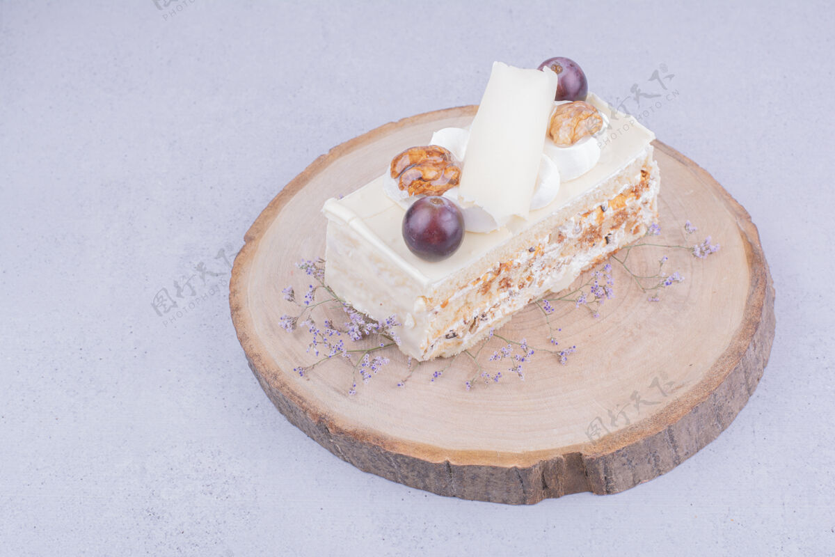 美味在木板上放一片椰子蛋糕 上面有葡萄和核桃面包房地壳糕点