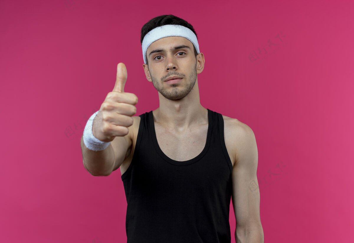 运动戴着头巾的年轻运动型男子向粉色竖起大拇指看头带年轻