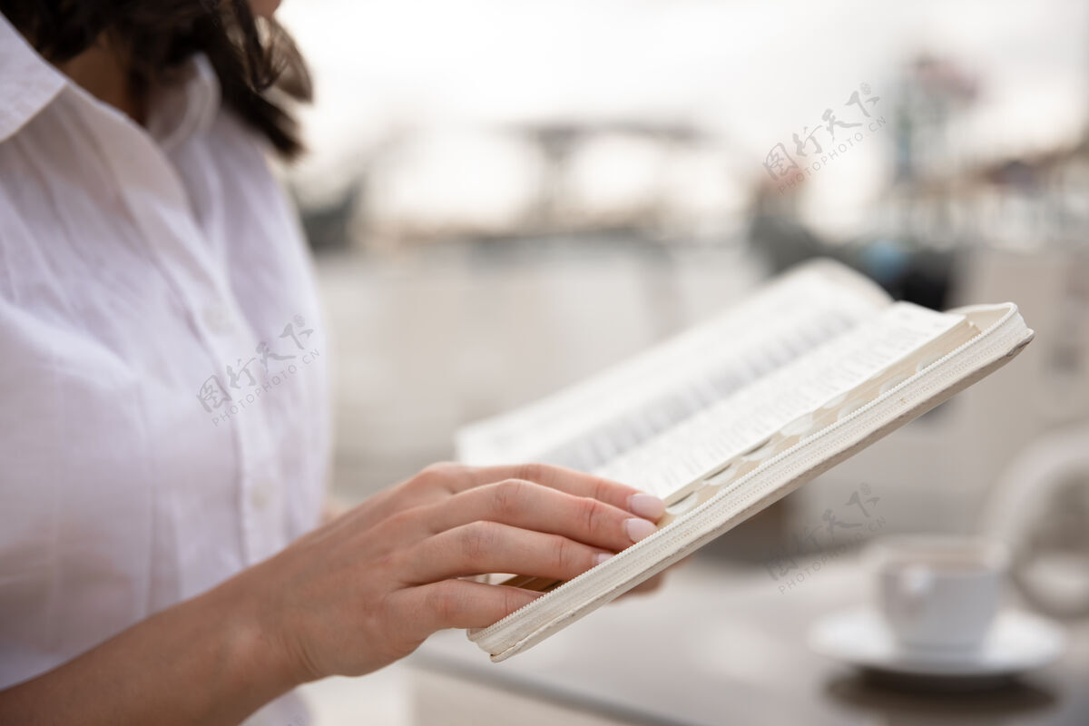 手女性手里拿着一本书的特写镜头女性知识书