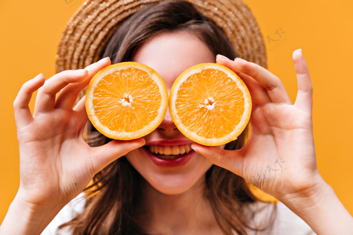 头发特写镜头中的年轻女孩在船上用多汁的橙子遮住眼睛女士女人水果