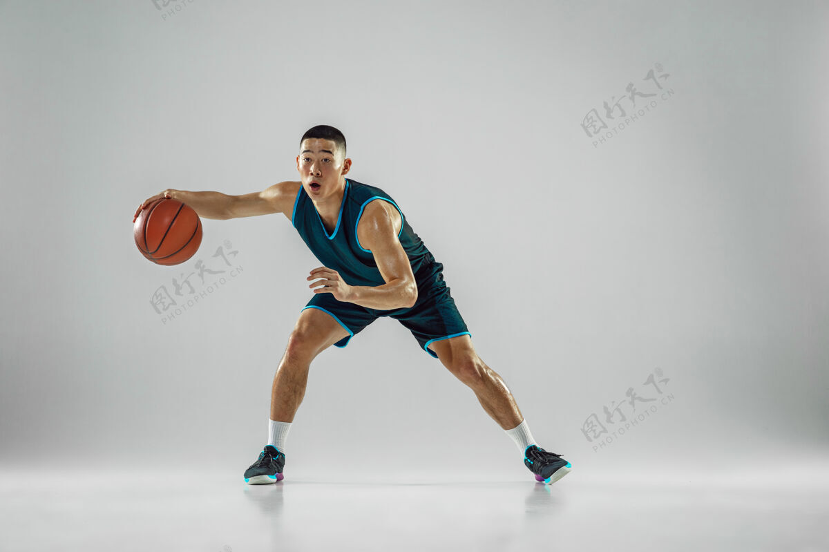 男子年轻的篮球队员穿着运动服训练 在运动中练习 在奔跑中运动 隔离在白墙上运动的概念 运动 活力和活力 健康的生活方式肌肉篮球力量