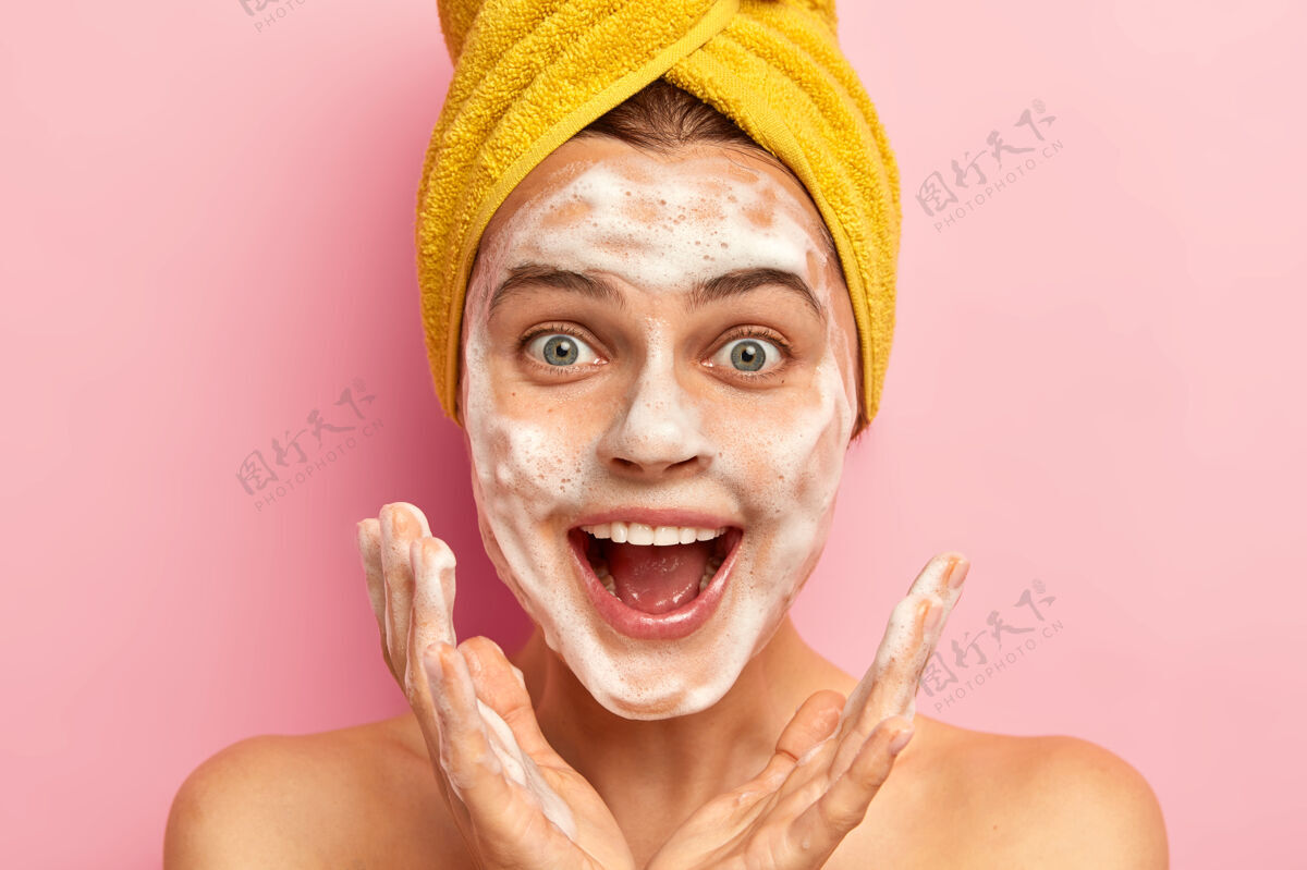 口腔惊喜交集的女人将手掌伸向脸 露出喜悦的表情 在浴室照镜子 用卫生皂洗脸 旁白泡沫惊喜