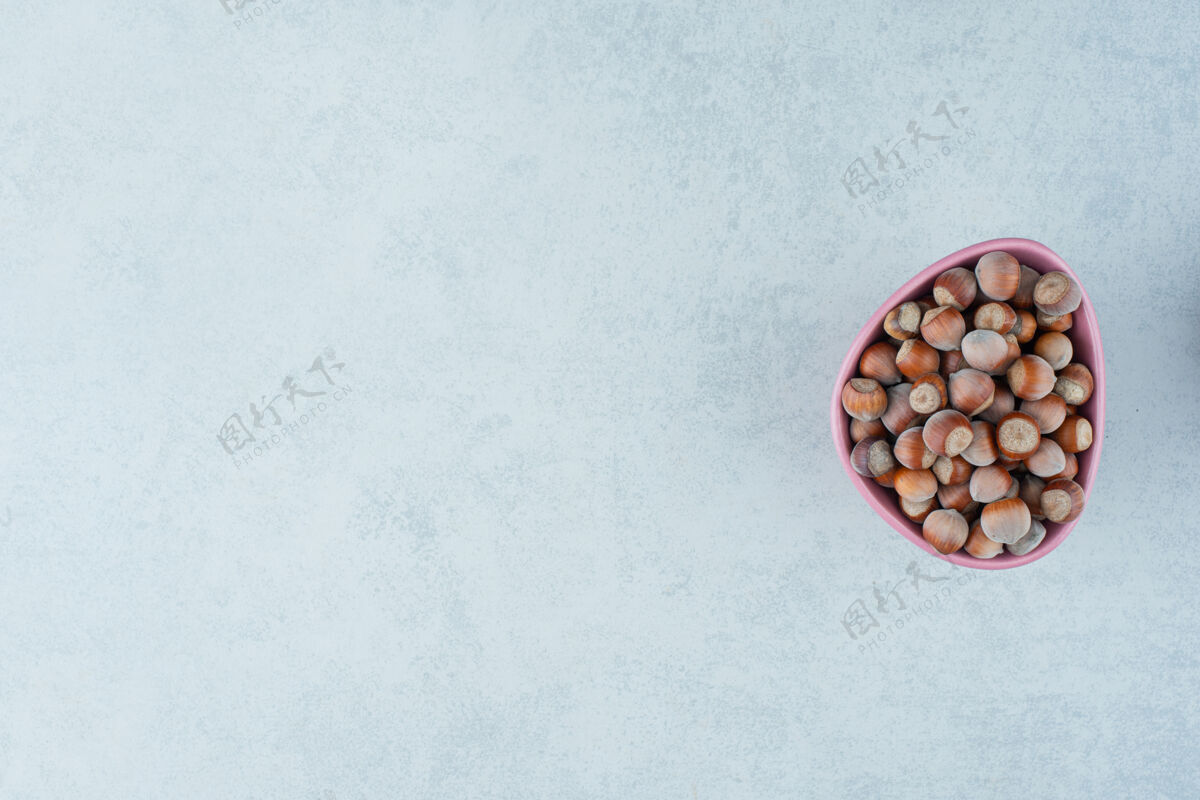 干在大理石背景上放满坚果的粉红色小盘高质量照片吃食物健康