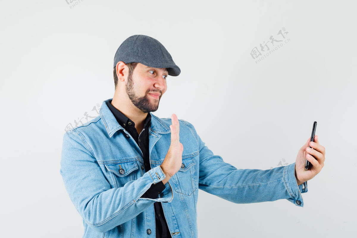 尊重复古风格的男士 穿着夹克 帽子 衬衫 在打视频电话时显示告别手势 看上去很有礼貌 正面视图男人时尚手势