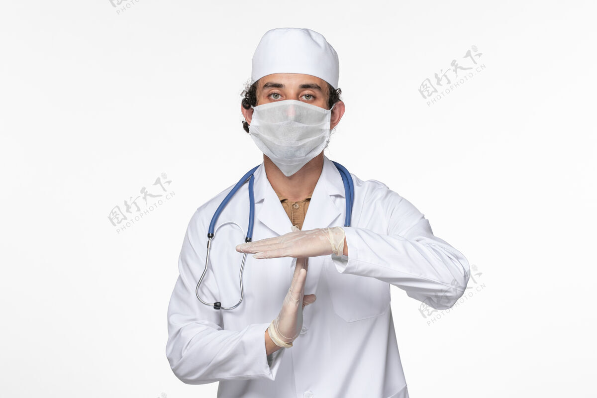 外套正面图男医生穿着医疗服 戴着无菌口罩 以防冠状病毒在白墙上大流行灭菌医疗正面