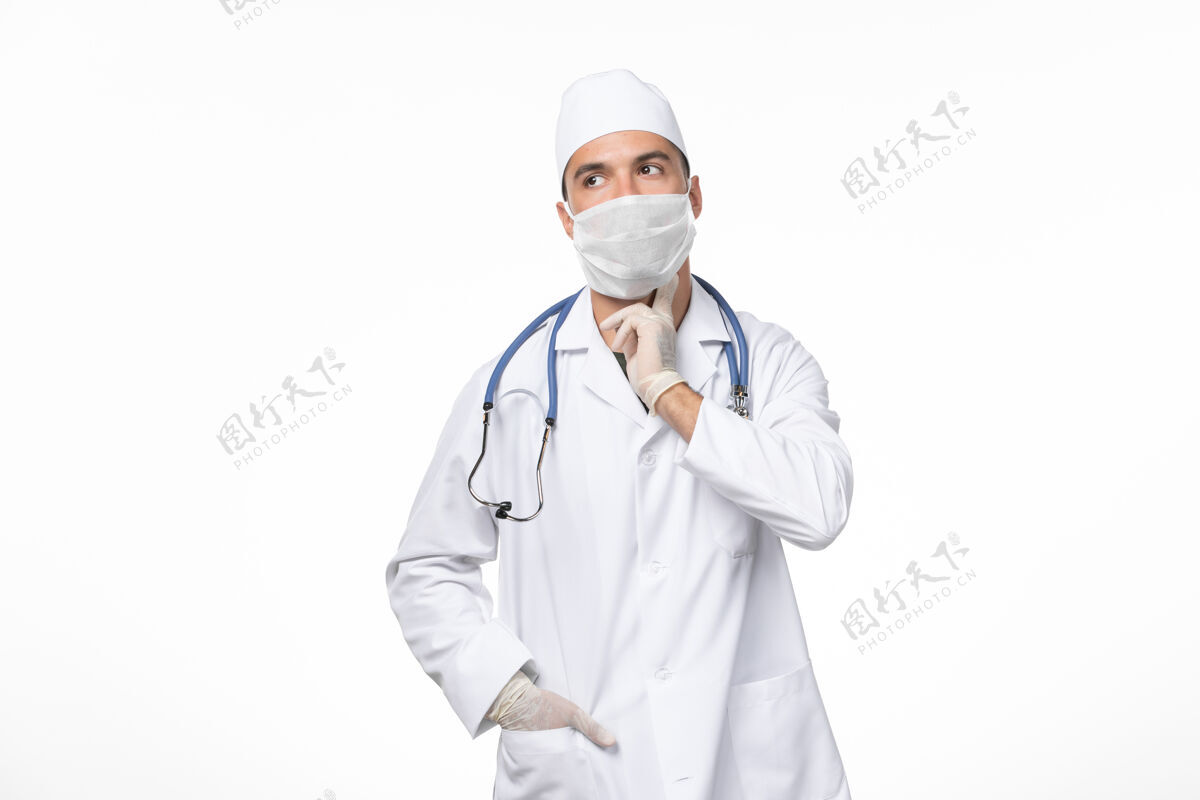 制服正面图：男医生穿着医疗服 戴着口罩 因为白墙病毒感染了柯维德大流行性疾病冠状病毒防护医生专业人员