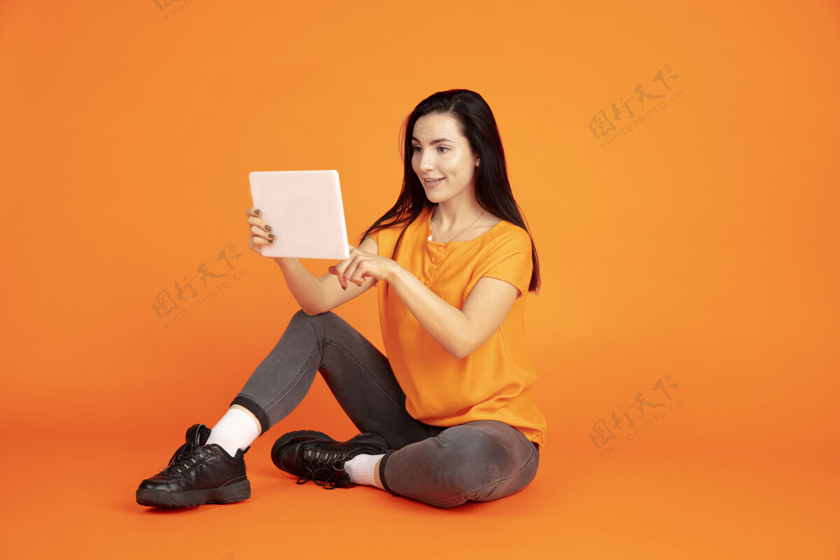 专业橙色空间上的白种人年轻女子的肖像穿着衬衫的漂亮深色女模特表情黑发表达