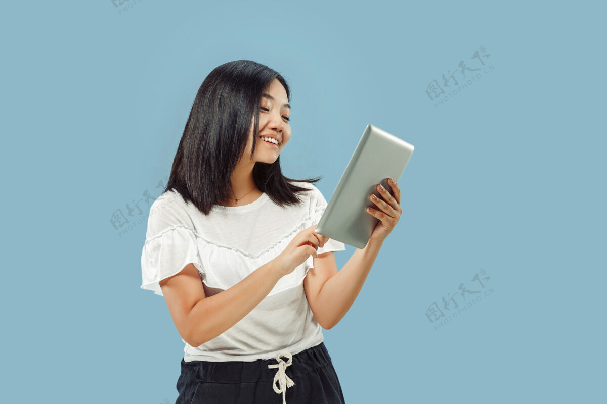 韩语蓝色空间上的韩国年轻女子半身像身穿白衬衫的女模特使用平板电脑 面带微笑专业衬衫工作