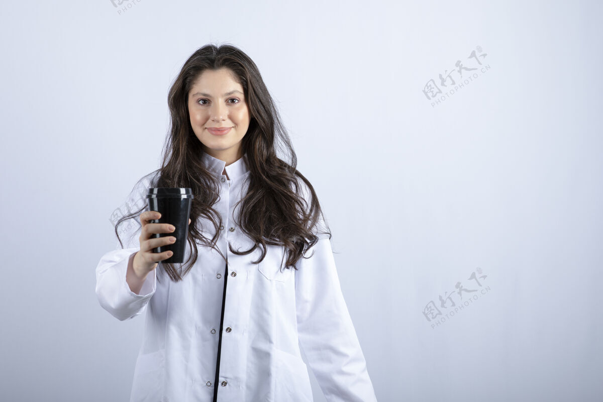 休息一张女医生和一杯咖啡摆姿势的照片医药职业制服