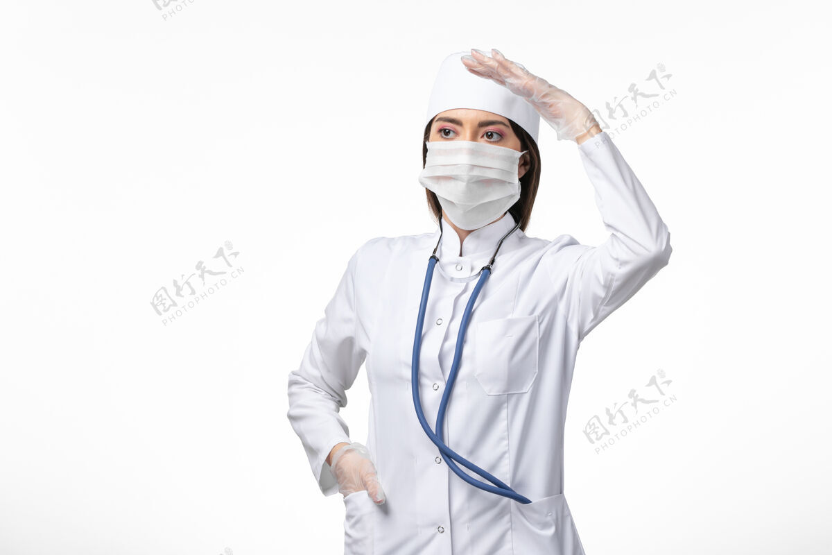 面具正面图女医生身穿白色无菌医疗服 带口罩 因白墙上冠状病毒病大流行冠状病毒人冠状病毒到期
