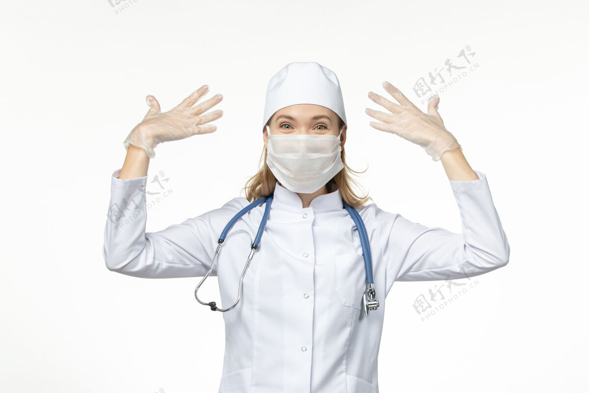灯光正面图女医生穿着医疗服戴着口罩和手套因冠状病毒对光台病毒冠状病毒-大流行性疾病肖像穿戴正面