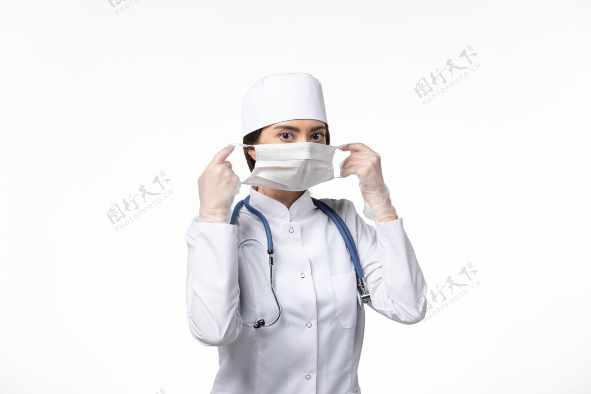 到期正面图女医生穿着白色无菌医疗服 戴着口罩 因柯维德-白墙病柯维德-大流行病毒病风衣男性冠状病毒防护