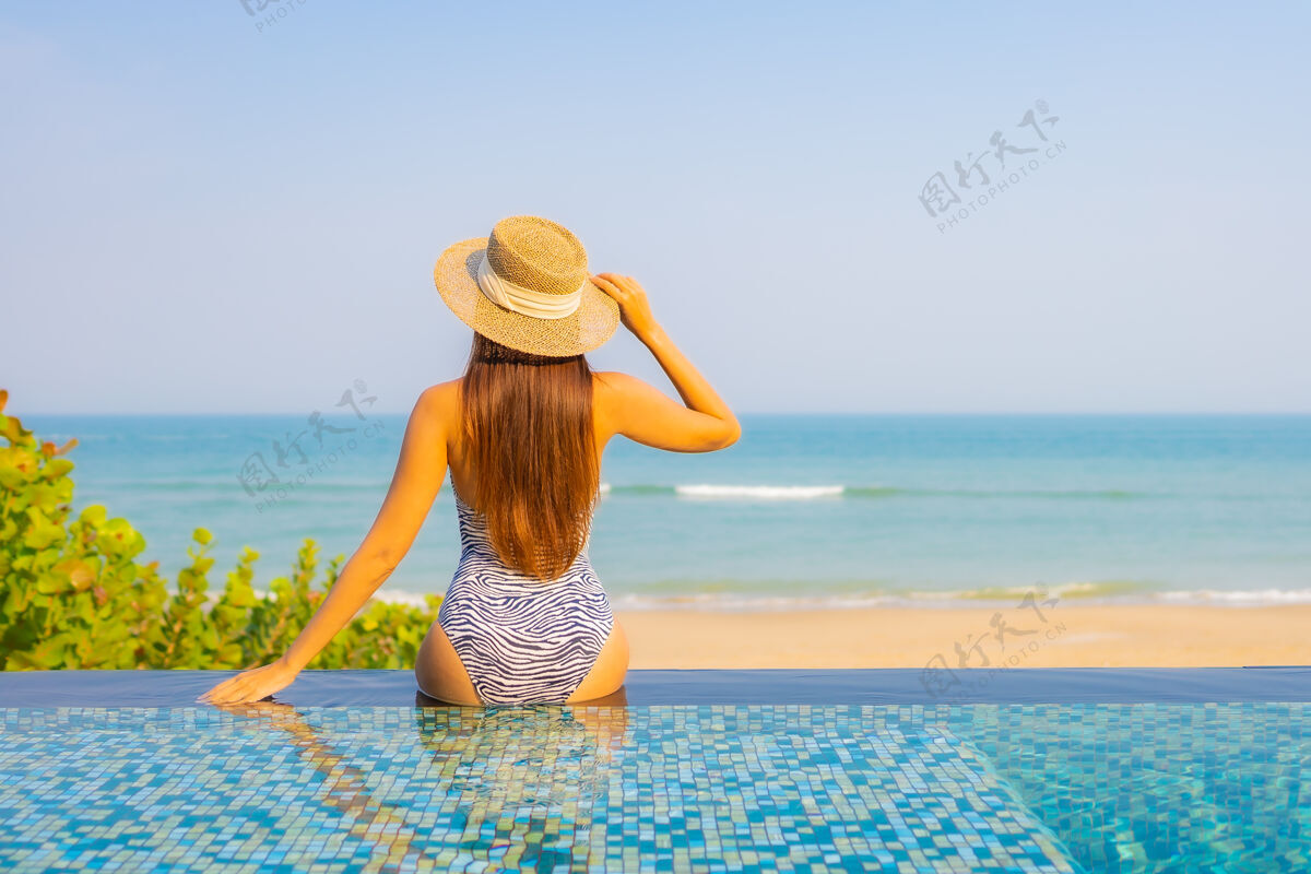 快乐美丽的年轻女子在泳池上放松的画像美丽乐趣女人