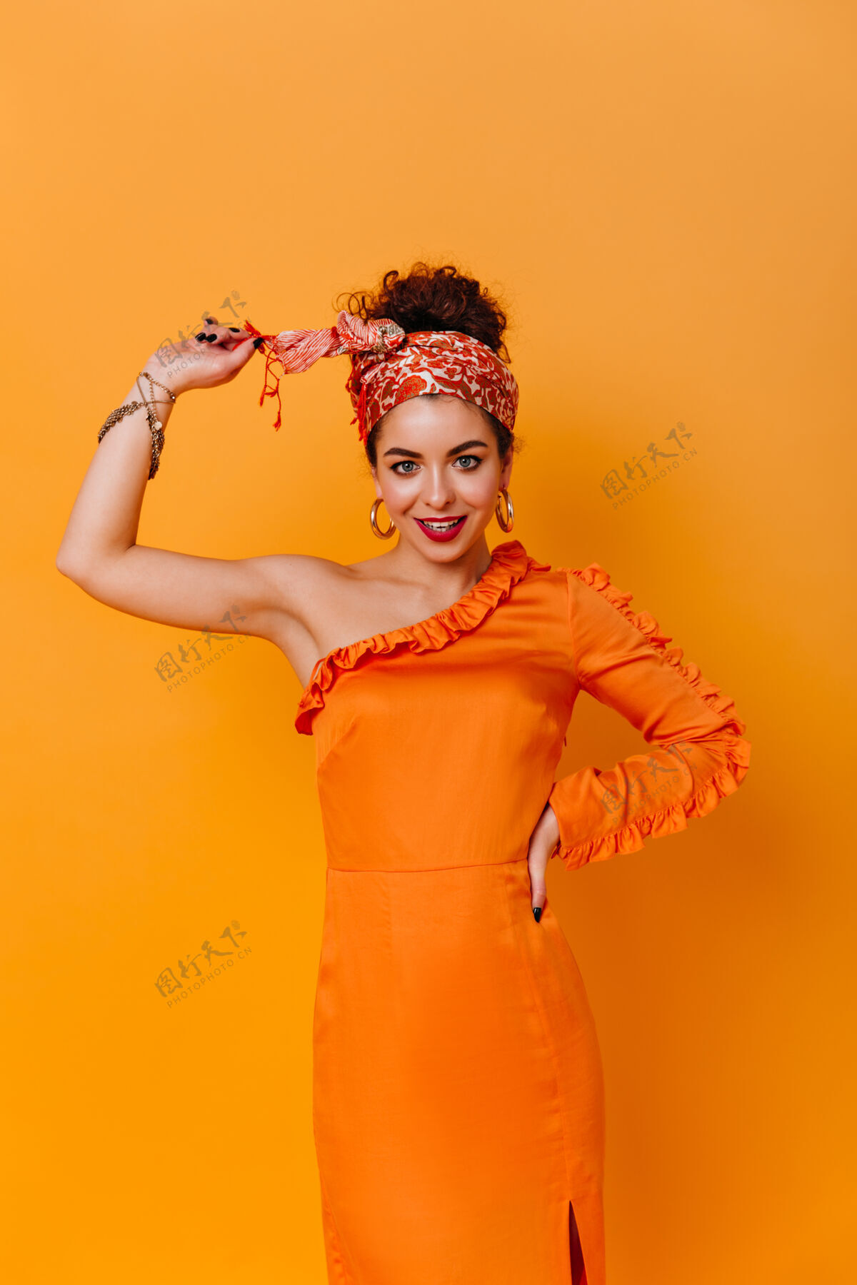 服饰身材苗条的女士身着优雅的橙色连衣裙 头戴非洲风格的头巾 在橙色的空间里露出甜美的笑容化妆现代瘦身