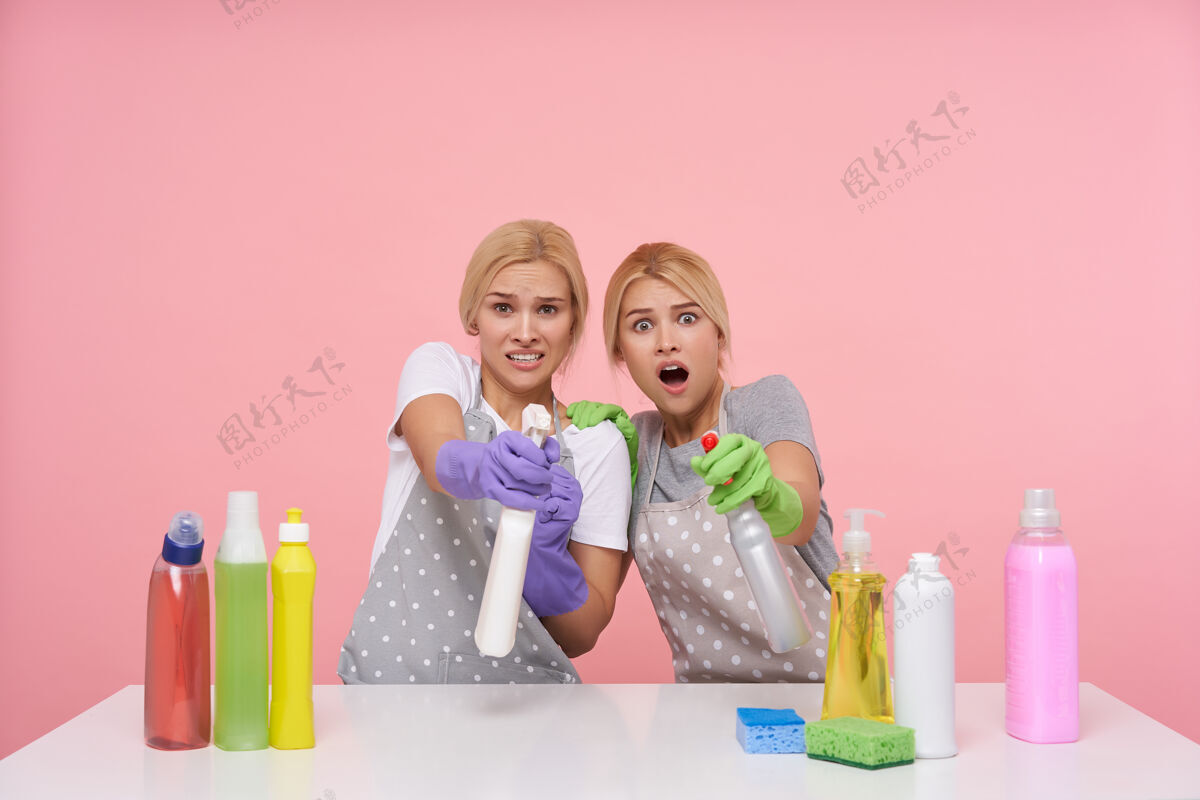 清洁年轻的金发可爱的主妇们戴着橡胶手套准备春季大扫除皱眉女士制服