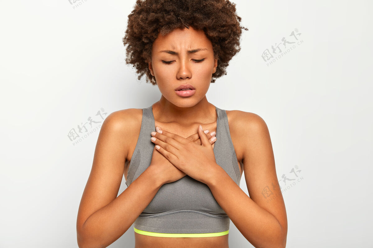 灰色沮丧的黑皮肤美国黑人妇女患有急性胸痛 穿着灰色运动胸罩 隔离在白色背景上不满意美国压力