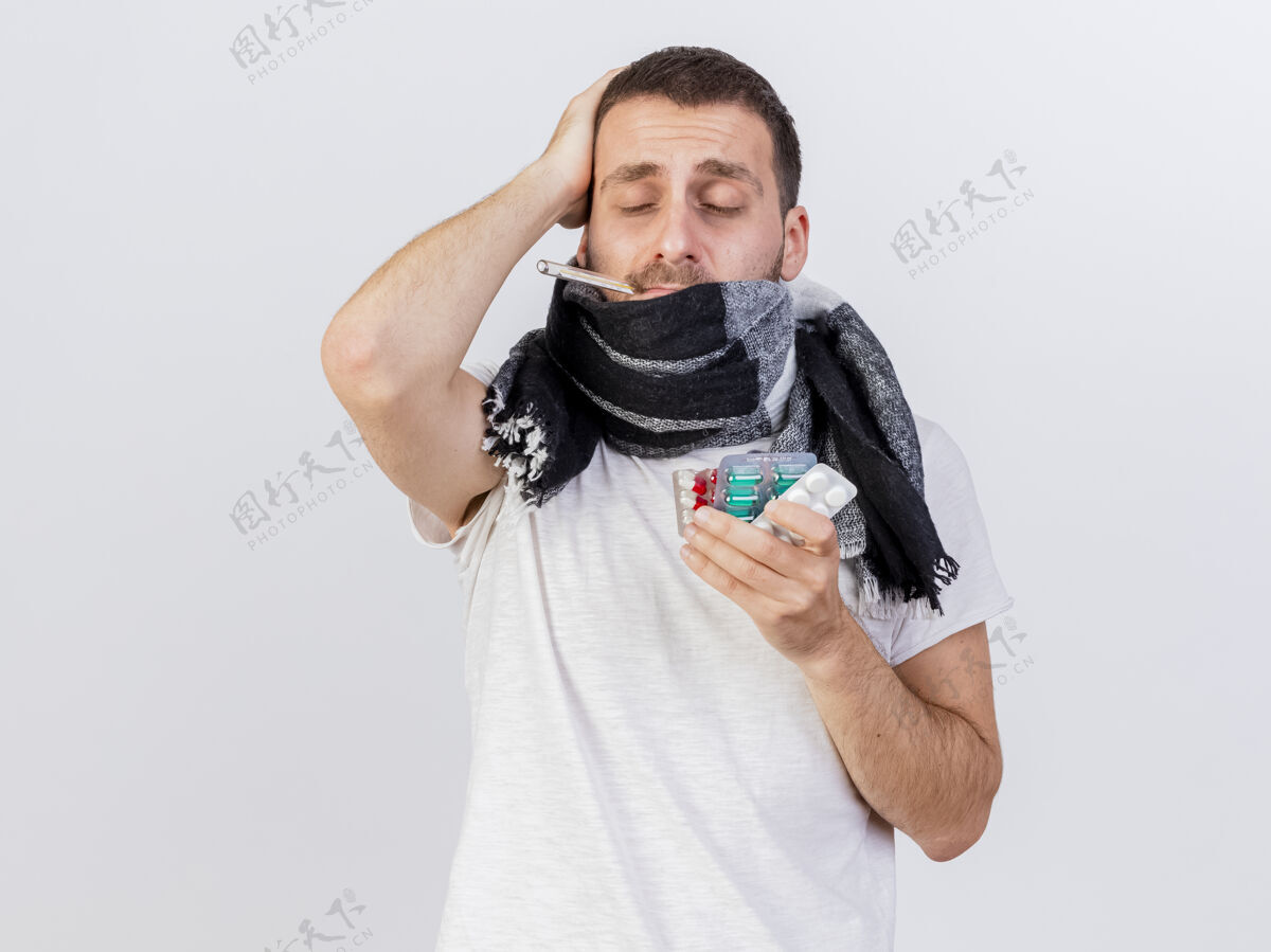 男人闭着眼睛 戴着方格布裹着的围巾 拿着药片的年轻病患格子布放年轻人