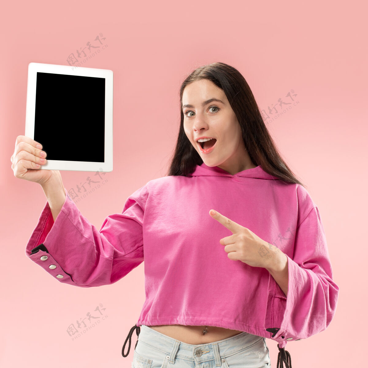 营销一个自信的休闲女孩的肖像 显示笔记本电脑的空白屏幕隔离在粉红色的空间显示器手Pc