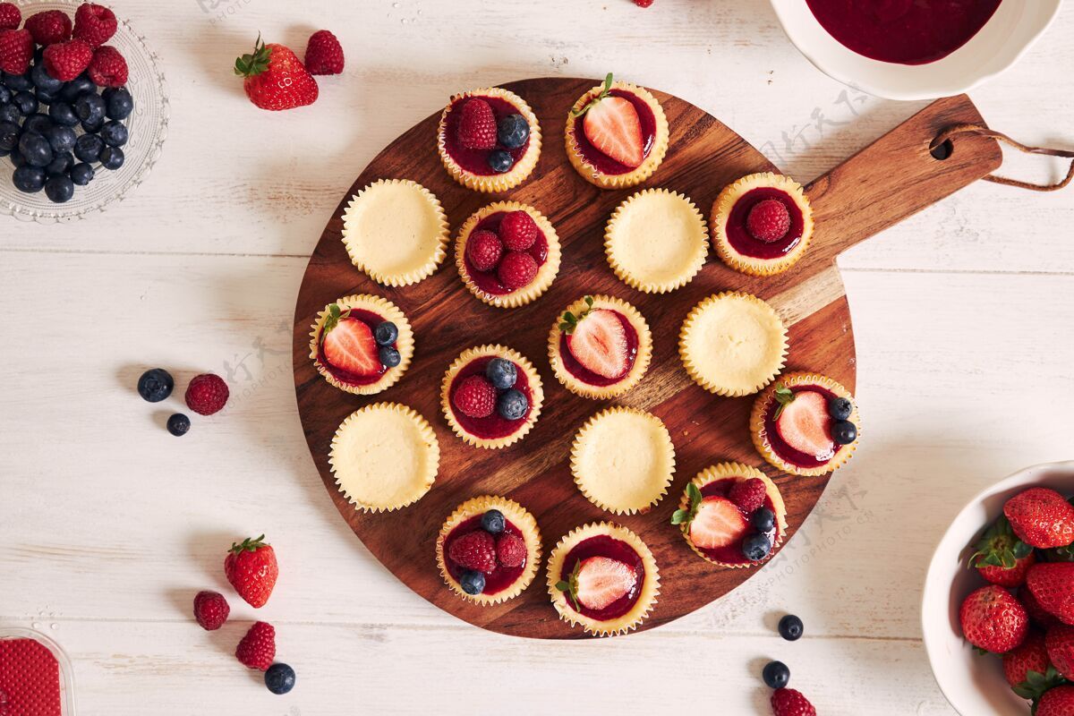 吃高角度拍摄的奶酪蛋糕与水果果冻和水果在一个木制的盘子糖浆果高角度
