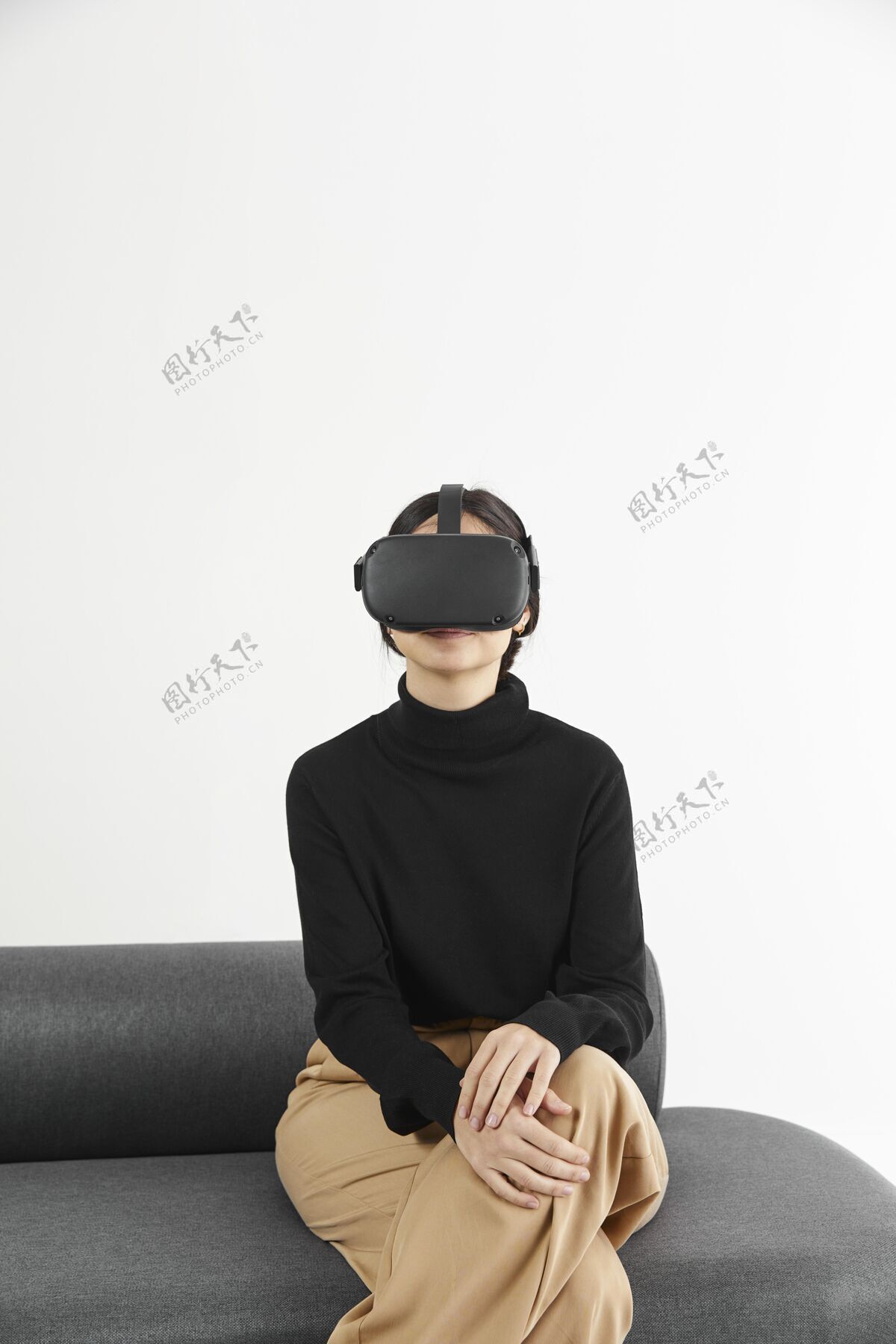 虚拟现实耳机沙发上戴着虚拟现实耳机的女人设备室内科技