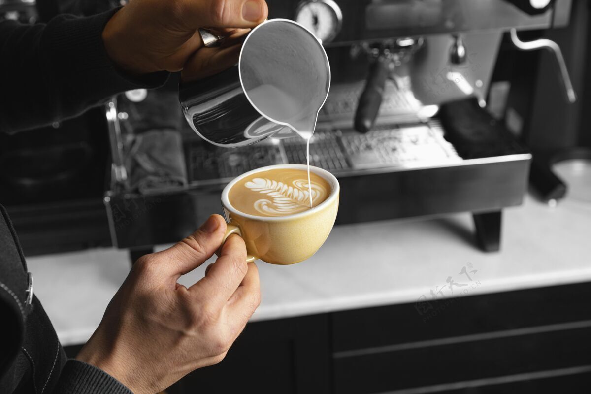 豆子特写手倒牛奶在美味的咖啡杯工作咖啡师饮料