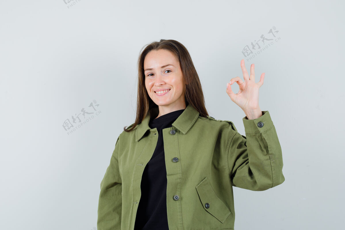 积极身穿绿色夹克的年轻女子 姿态不错 看上去很乐观 正对着前方看时尚乐观好