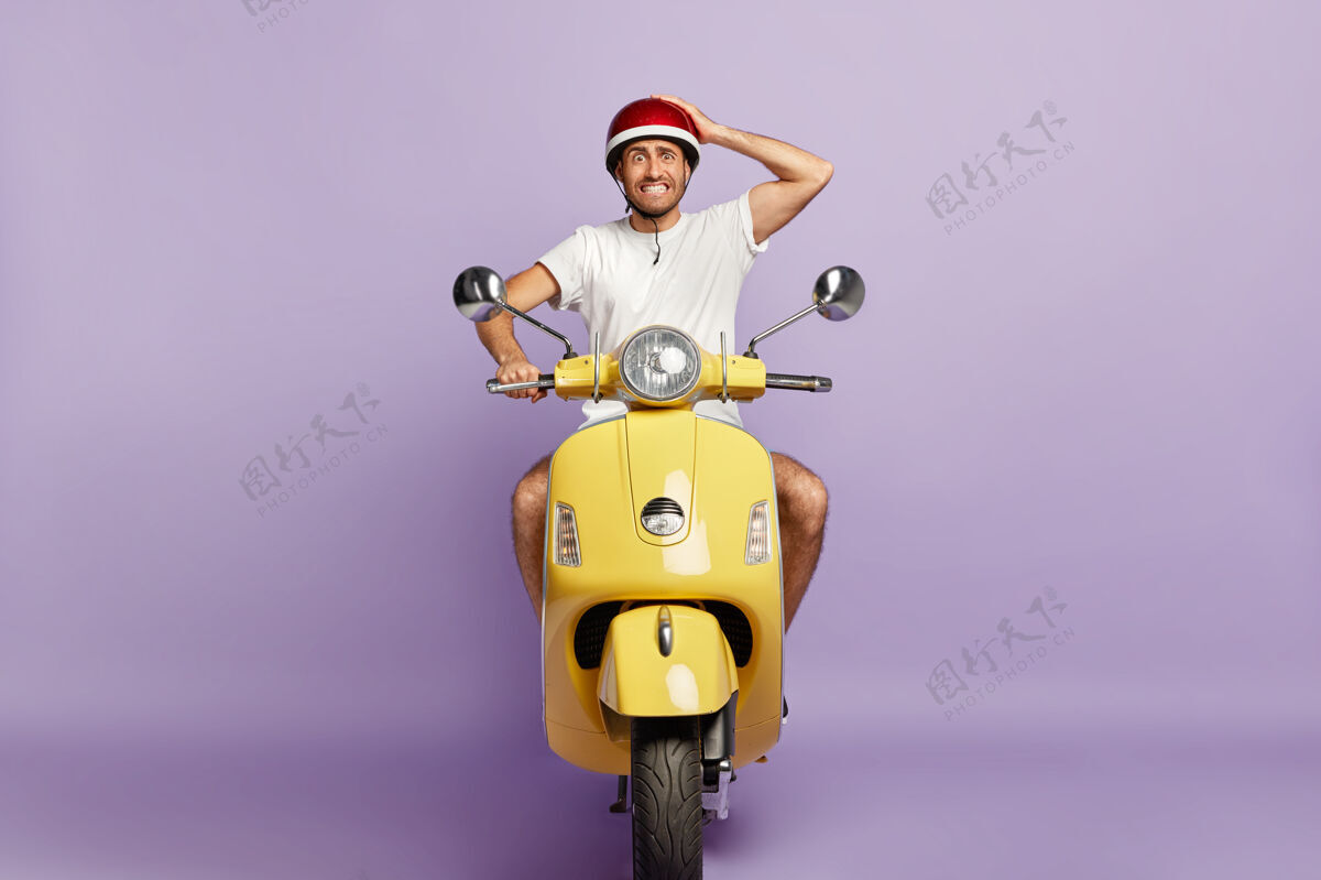司机戴头盔的尴尬家伙开着黄色摩托车驾驶头盔自行车