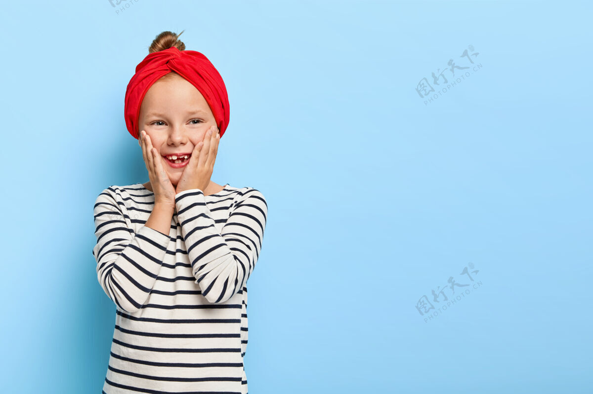 玩快乐时尚的小女孩与红色头带摆姿势孩子室内小