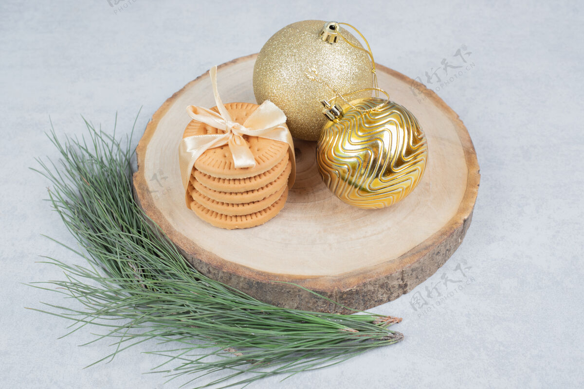 木板一堆饼干用彩带和圣诞球绑在木板上高质量的照片树枝松树节日