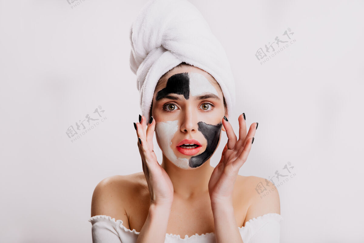 黏土洗完澡的绿眼睛模特用白黑相间的粘土做面膜头上戴着白毛巾的女孩模特头发毛巾