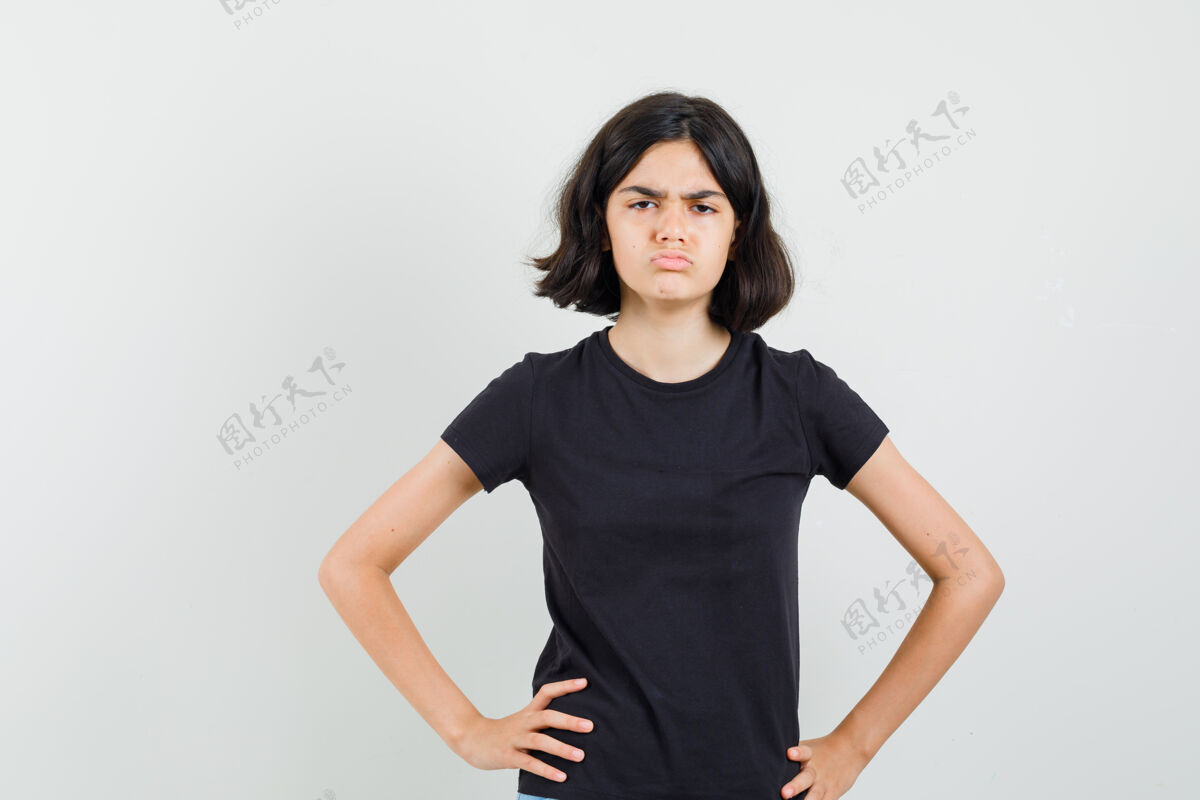 女性小女孩站在那里 手放在腰上 穿着黑色t恤 看上去很阴郁正视图看美丽腰