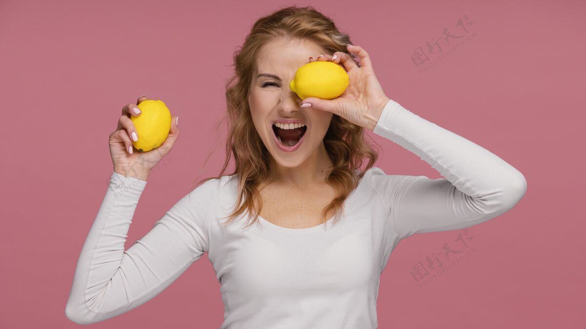 笑一个拿着柠檬和柠檬的顽皮女人的画像？笑女人玩年轻