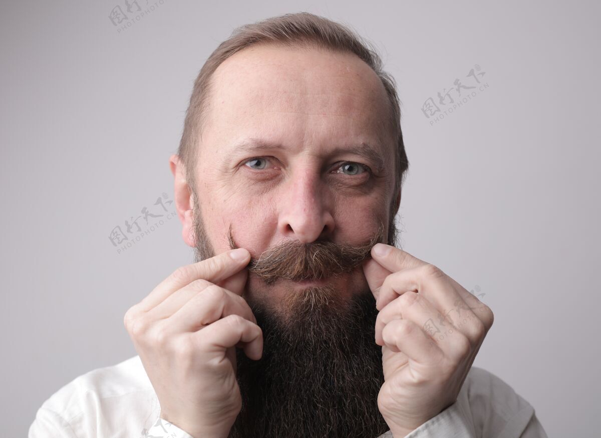 自信一个留着长胡子的男人站在一堵灰色的墙前微笑着衬衫年轻胡子