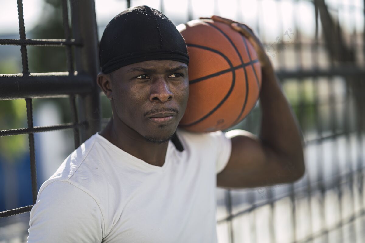 强壮特写镜头中 一名身穿白衬衫的非裔美国男子肩上扛着球姿势健康手臂